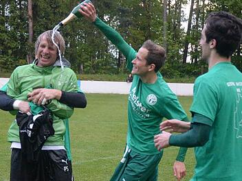 Der TSV Neudrossenfeld ist erstmals in die Fußball-Bayernliga aufgestiegen. Hier verpasst Andre Lutz (Mitte) seinem Trainer Peter Schmidt die obligatorische Sektdusche. Foto: Peter Mularczyk