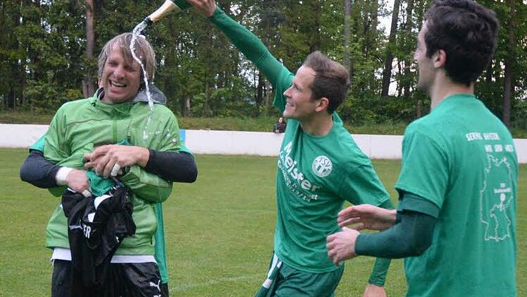 Der TSV Neudrossenfeld ist erstmals in die Fußball-Bayernliga aufgestiegen. Hier verpasst Andre Lutz (Mitte) seinem Trainer Peter Schmidt die obligatorische Sektdusche. Foto: Peter Mularczyk