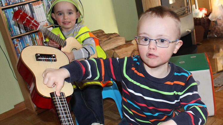 Der dreijährige Matthias und sein älterer Bruder Johannes (von links) lieben das Musik machen. Doch lange hält es Johannes nicht im Sitzen aus. Viel lieber schaut er sich den Besuch mit der großen Kamera mal aus der Nähe an. Foto: Lisa Kieslinger