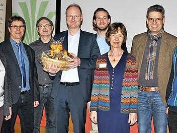 In die Mitte genommen: Diplommeteorologe Sven Pl&ouml;ger wurde nach seinem Vortrag von den Vertretern des veranstaltenden Netzwerks mit Honig-Produkten verabschiedet, auf dem Bild (von links) Annette Seehaus-Arnold (Imker), Mathias Kl&ouml;ffel (BBV), Helmut Schwartl (Energie-Initiative), Sven Pl&ouml;ger (Referent), Felix Schmidl (Projekt boden:st&auml;ndig), Susanne Richter (BN), Michael Diestel (BBV) und Helmut B&auml;r (BN).  Foto: Regina Vossenkaul