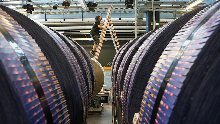 Veranstaltungstechniker Jan Görrißen beim Aufbau der Beleuchtungstechnik. Da, wo noch die schweren Rollen mit Werbeprospekten lagern, werden am Samstag die Bamberger Symphoniker auftreten. Foto: Matthias Hoch