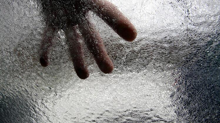 Eine Autoscheibe wird von einer Eisschicht bedeckt. Foto: Daniel Karmann/dpa