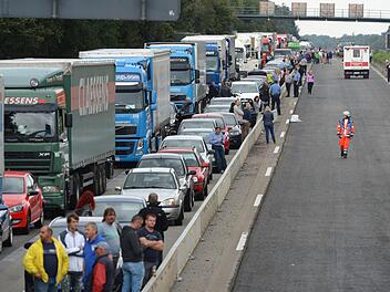 Lkws und Pkws stehen am 01.09.2014 nach einem schweren Unfall auf der Autobahn A3 bei Obertshausen (Landkreis Offenbach, Hessen) im Stau. Bei dem Unfall mit mehreren Fahrzeugen ist ein Mensch ums Leben gekommen. Vier Personen wurden nach Polizeiangaben verletzt. Die Autobahn musste voll gesperrt werden. Foto: Arne Dedert/dpa