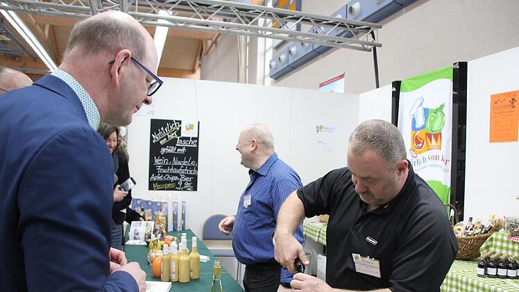 Zeils Bürgermeister Thomas Stadelmann (links) probiert am Stand von Oliver Ulbrich (rechts, "Hammerschmiedsmühle") einen mit Rosenlikör verfeinerten Secco.