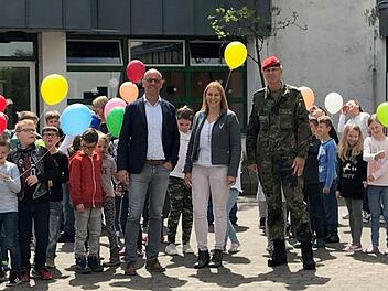 Mit Luftballons verabschiedeten sich die Schüler vom Truppenübungsplatz. Bürgermeister Gerd Kleinhenz (von links), Schulleiterin Christiane Helfrich und Oberstleutnant Roman Jähnel von der Bundeswehr würdigten die 25-jährige Schulgeschichte in der Rhönkaserne. Foto: Ulrike Ziegler
