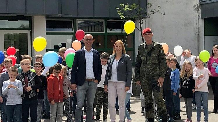 Mit Luftballons verabschiedeten sich die Schüler vom Truppenübungsplatz. Bürgermeister Gerd Kleinhenz (von links), Schulleiterin Christiane Helfrich und Oberstleutnant Roman Jähnel von der Bundeswehr würdigten die 25-jährige Schulgeschichte in der Rhönkaserne. Foto: Ulrike Ziegler