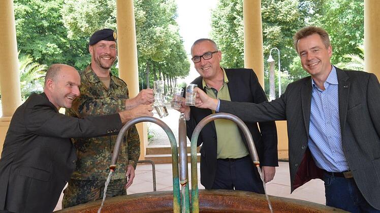 Auf gute Zusammenarbeit stoßen in Bad Bocklets Brunnenbau mit Heilwasser an (von links) Rhön GmbH-Geschäftsführer Thorn Plöger, der Hammelburger Kommandeur Simon Leidner, Bürgermeister Andreas Sandwall und Kurdirektor Thomas Beck.  Foto: Isolde Krapf