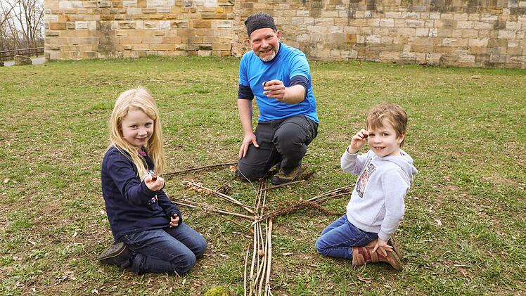 Wandertrainer Sven hilft Lotte und Leo, mit ihren gesammelten Schätzen ein Bild zu legen.  Foto: Barbara Herbst