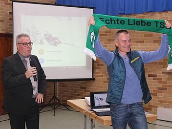 Der Vorsitzende Achim Brückner hat dem Spitzensportler Sven Fischer einen Schal der TSG Niederfüllbach überreicht, den dieser begeistert hochhält. Foto: Michael Stelzner