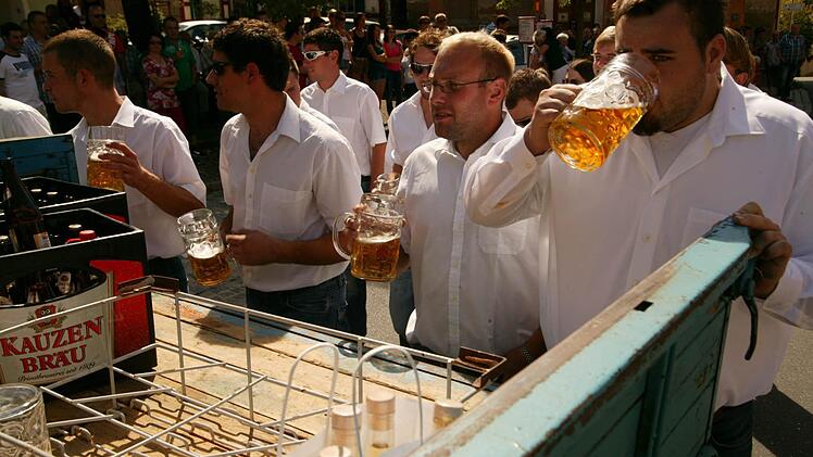 Die Musiker und Burschen spielen  und trinken um die Wette.