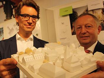 Architekt Thomas Steimle und Landrat Thomas Bold mit dem Modell des Erweiterungsbaus: Durch die zum Teil zwei- und zum Teil dreigeschossige Bauweise fügt sich das Gebäude (Bildmitte) gut in das Ensemble zwischen Rathaus (vorne), Jakobuskirche (rechts) und Landratsamt (dahinter) ein. Fotos: Ralf Ruppert