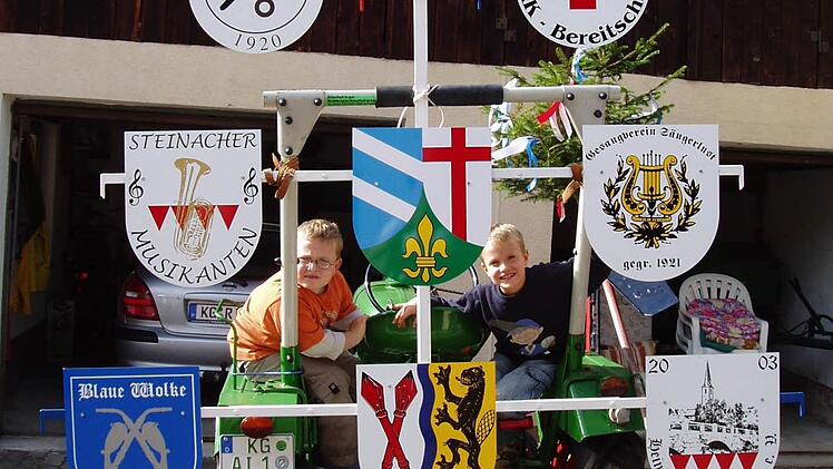 Zwei Buben, Bastian Wehner (links) und Franz-Xaver Rosshirt, mit dem Wappenbaum, an den die örtlichen Vereine ihre Wappen gehängt haben. Foto: Frank Schmitt