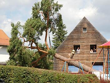 Sanft legt der Kran Grubs gefallenes Wahrzeichen auf der Straße neben dem Spielplatz ab. Fotos: Rainer Lutz