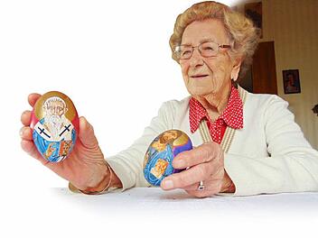 Maria Lenhart zeigt zwei der von ihrem Ehemann gemalten Ikoneneier. Foto: Petra Malbrich