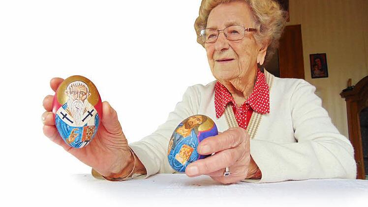 Maria Lenhart zeigt zwei der von ihrem Ehemann gemalten Ikoneneier. Foto: Petra Malbrich