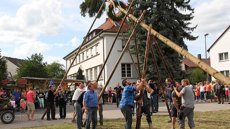 Mit viel Muskelkraft wuchten die Trailsdorfer den Kerwasbaum in die Höhe.  Foto: Erlwein