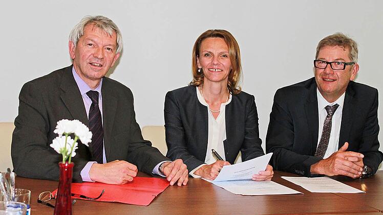 Monika Röther bei der Vertragsunterzeichnung mit Landrat Johann Kalb (links) und Geschäftsführer Manfred Fischer (rechts)