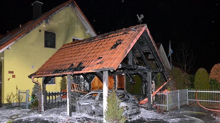 Total ausgebrannt sind am Montagabend ein Pkw und ein Carport in Oerlenbach in der Karl-Karch-Straße. Foto: Peter Rauch