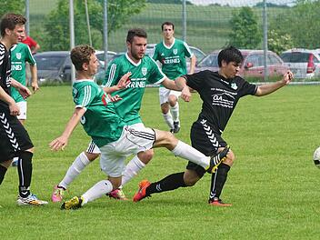 Die Sander Tobias Krines und Dominik Schmitt (von links vorne in den grünen Trikots) versuchen, den Forster Andreas Rösner (rechts) vom Ball zu trennen.