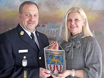 Wilhelmsthals Bürgermeisterin Susanne Grebner beglückwünscht KBI Frank Fischer zur Beförderung als Kreisbrandinspektor und überreicht ihm das Gemeinde-Wappen. Foto: Heike Schülein