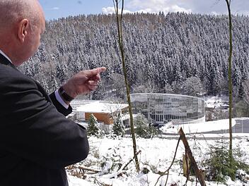 Bürgermeister Peter Ebertsch freut sich über die Zertifizierung des Tropenhauses und zeigt vor sich auf die neuerdings freigelegte Waldfläche oberhalb des gläsernen Bauwerks. Foto: Marco Meißner