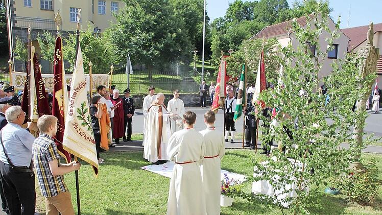 Pater Rudolf Theiler weiht bei der Fronleichnamsprozession in Ebern den Altar an der dritten Station am kirchlichen Kindergarten. Hier wie in vielen anderen Orten im Landkreis zogen die Gläubigen betend durch die Städte und Dörfer. Im Hintergrund ist das ehemalige Forstamt. Foto: Ralf Kestel
