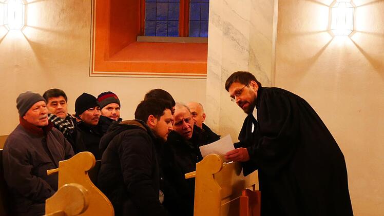 Pfarrer Martin Frenkler reicht in der evangelischen Stadtkirche Sankt Georg den türkischen Gästen seine Worte zur Übersetzung weiter.Manja von Nida