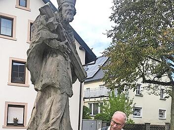 Restaurator Fröhlich versucht, Schriftzüge auf der Nepomukstatue in Marktleugast zu entziffern. Kreisheimatpfleger Siegfried Sesselmann sieht zu.