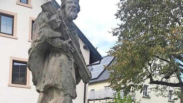 Restaurator Fröhlich versucht, Schriftzüge auf der Nepomukstatue in Marktleugast zu entziffern. Kreisheimatpfleger Siegfried Sesselmann sieht zu.