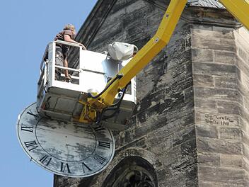 Jürgen Balbach hat das verwitterte Zifferblatt an der Südseite des Glockenturms der Kronacher Christuskirche abgenommen.  Fotos: Friedwald Schedel