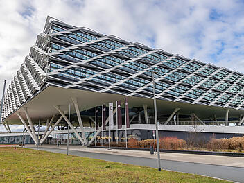 Hauptquartier der Adidas AG in Herzogenaurach, bekannt als "Arena" auf dem Adidas Campus. Die Aufnahme unterstreicht die Funktion des Gebäudes als zentraler Unternehmenssitz eines global führenden Unternehmens in der Sport- und Bekleidungsindustrie.