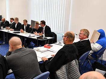 Zwei der Angeklagten suchten den Schutz vor den Kameras, zwei nicht. Während die beiden im Vordergrund Teilgeständnisse ablegten, schwiegen die beiden im Hintergrund zu den Vorwürfen.  Foto: Ronald Rinklef