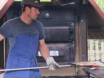Valeri Strasheim öffnet die Ofentüre und schwingt den dampfenden Zwiebelplootz auf dem Holzbrett mit dem langen Stiel auf den Tisch. Fotos: Gerd Schaar
