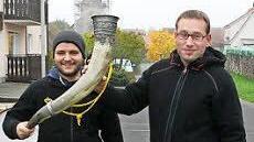 Ortsreferent Fabian Nöth und Houfree-Bursche Robin Hillenbrand stoßen mit dem gefüllten Trinkhorn an. Foto: Arnold Nöth