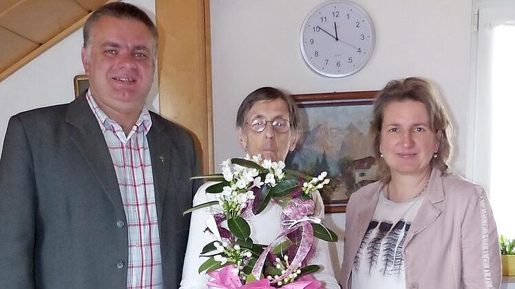 Jubilarin Hedwig Stündl mit Blumen in der Bildmitte zusammen mit Pfarrer Michail Osak (links) und Bürgermeisterin Doris Leithner-Bisani (rechts). Foto: Klaus-Peter Wulf