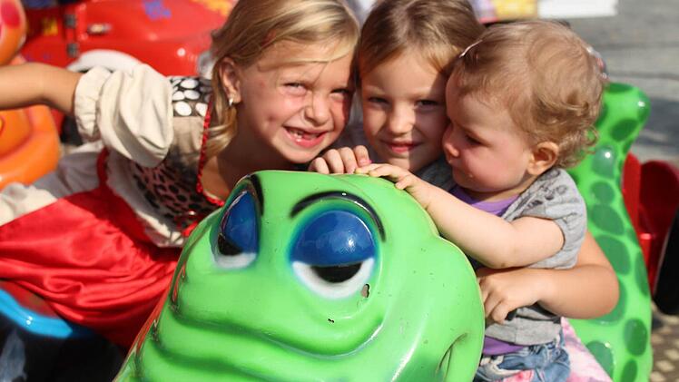 Lilli Mahr (von links) und ihre Cousinen Emma und Leni haben eine Menge Spaß im Kinderkarussell.   Foto: Sina Mattheus