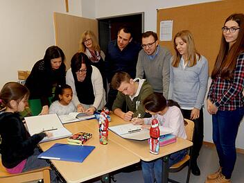 So sieht das aus, wenn gemeinsam gelernt wird: Wirtschaftsjunioren und Schulleiterinnen (hinten von links) Manuela Küfner, Angelika Schmitt, Andrea Kastner-Thiel, Sebastian Pollach sowie Sebastian Sahlender schauten sich die Gruppenarbeit einmal näher an. Foto: Günther Geiling