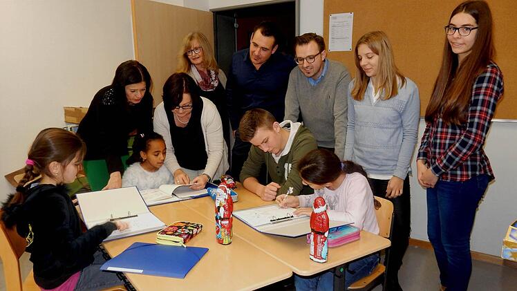 So sieht das aus, wenn gemeinsam gelernt wird: Wirtschaftsjunioren und Schulleiterinnen (hinten von links) Manuela Küfner, Angelika Schmitt, Andrea Kastner-Thiel, Sebastian Pollach sowie Sebastian Sahlender schauten sich die Gruppenarbeit einmal näher an. Foto: Günther Geiling