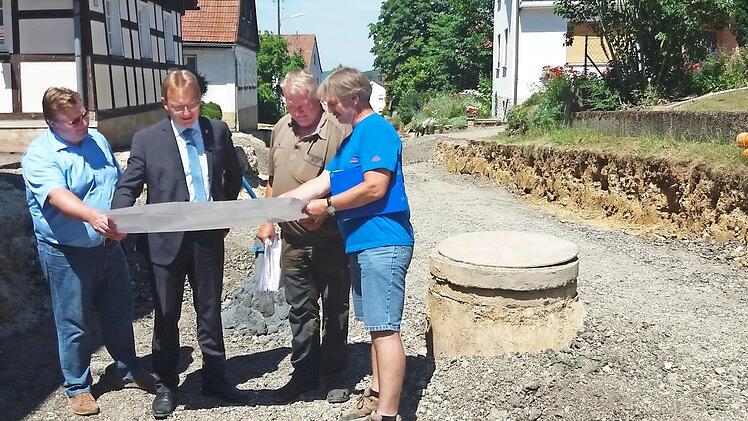 Für die neue Straße musste das Erdreich tief ausgehoben werden, weil der Untergrund ungeeignet war. Hier besichtigte Bürgermeister Bernd Rebhan (2. v. l.) die Baustelle. Foto: Markt Küps