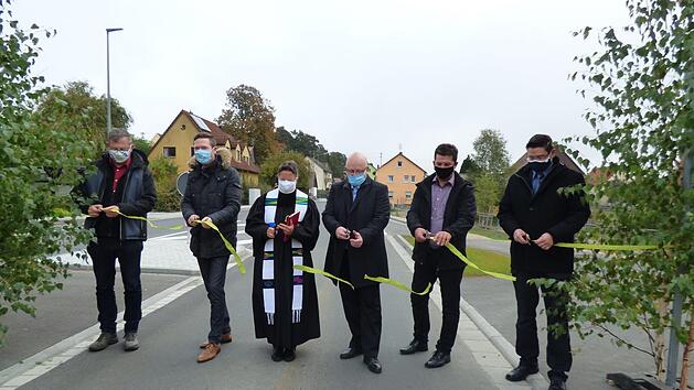 Verkehrsfreigabe mit Corona-Schutzmaske vor Geusmanns: Roland Kasel, Landrat Florian Wiedemann, Pfarrerin Heike &Ouml;ffner, Ingenieur Matthias Kraft, Pottensteins B&uuml;rgermeister Stefan Fr&uuml;hbei&szlig;er und Alexander Lauer (von links) durchschneiden das Band und geben die Stra&szlig;e frei. Fotos: Thomas Weichert