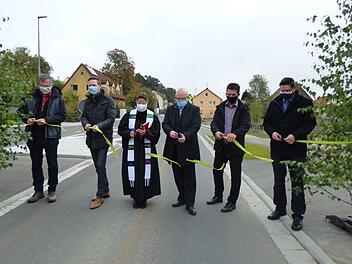 Verkehrsfreigabe mit Corona-Schutzmaske vor Geusmanns: Roland Kasel, Landrat Florian Wiedemann, Pfarrerin Heike Öffner, Ingenieur Matthias Kraft, Pottensteins Bürgermeister Stefan Frühbeißer und Alexander Lauer (von links) durchschneiden das Band und geben die Straße frei. Fotos: Thomas Weichert