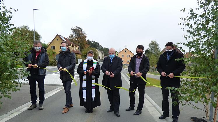 Verkehrsfreigabe mit Corona-Schutzmaske vor Geusmanns: Roland Kasel, Landrat Florian Wiedemann, Pfarrerin Heike Öffner, Ingenieur Matthias Kraft, Pottensteins Bürgermeister Stefan Frühbeißer und Alexander Lauer (von links) durchschneiden das Band und geben die Straße frei. Fotos: Thomas Weichert