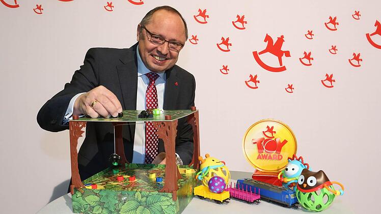 Ernst Kick, Vorstandsvorsitzender der Spielwarenmesse spielt mit dem Spiel "Spinderella" .
