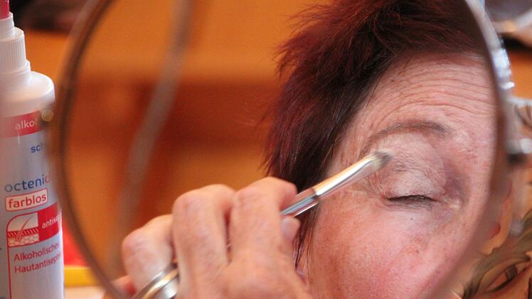 Eine der Teilnehmerinnen trägt Lidschatten auf.  Foto: Ulrike Müller