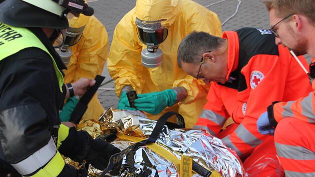 Die Einsatzkr&auml;fte bereiten eine kontaminierte Person f&uuml;r den Abtransport vor. Fotos: Veronika Schadeck