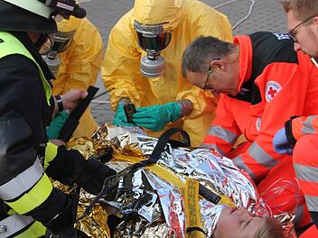 Die Einsatzkräfte bereiten eine kontaminierte Person für den Abtransport vor. Fotos: Veronika Schadeck