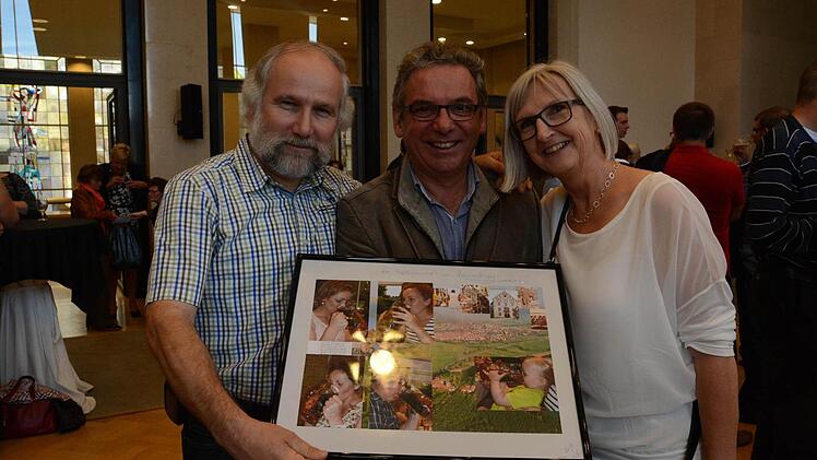Lothar und Ulrike Sikora bringen Francis Goris Fotos von Hammelburger Begegnungen mit der Laternenmaß mit .