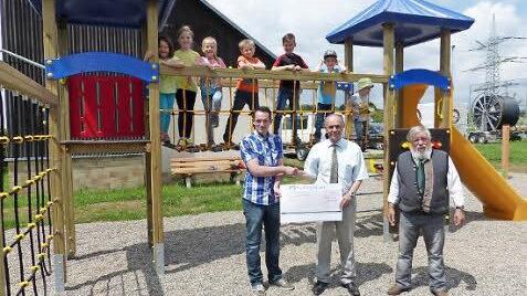 Stellvertretend für die drei Neuensorger Vereine übergaben Michael Kühnel (vorne, links) und Bruno Tittel (vorne, rechts) auf dem Spielareal die 1000 Euro an Bürgermeister Franz Uome. Auf dem neuen Kletterturm einige Neuensorger Kinder.  Foto: Klaus-Peter Wulf
