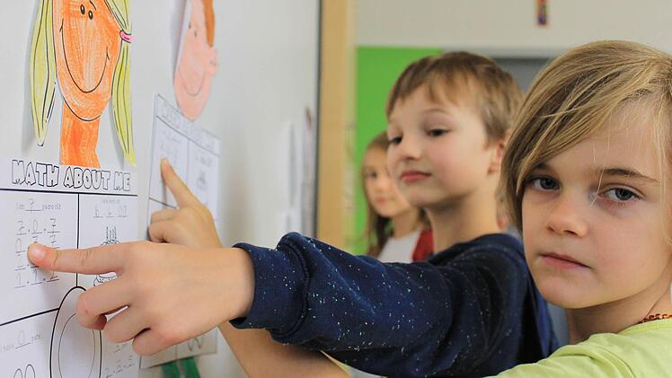 Karlsson, Felix und Nele (von hinten) zeigen, was sie im englischsprachigen Matheunterricht in der zweiten Klasse schon alles gelernt haben. Foto: Dominic Buckreus