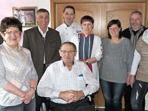 Heinz Kauper (sitzend) mit (von links) Klaus Zahner, Ehefrau Marianne, Bürgermeister Siegfried Decker, William Limmer, Daniela Kauper, Verkäuferin Elke Griebel, FC-Vorsitzendem Dieter Mühlbauer und Verkäuferin Daniela Zischka. Foto: Werner Reißaus